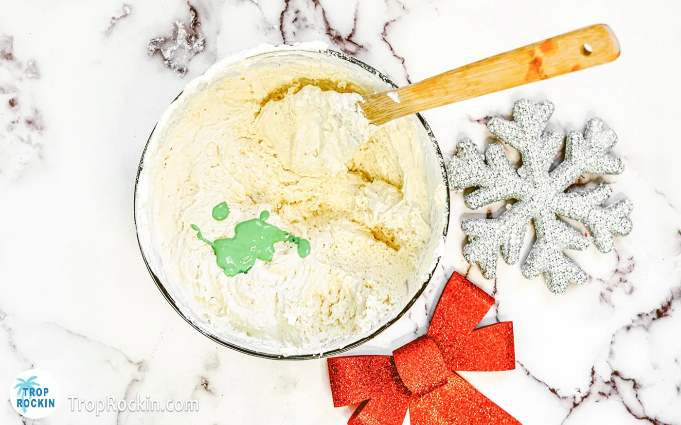 Green food coloring added to the bowl of Grinch dip ingredients.