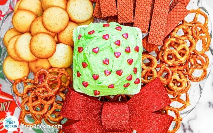 Bowl of Grinch Dip with red hearts on cookie platter.