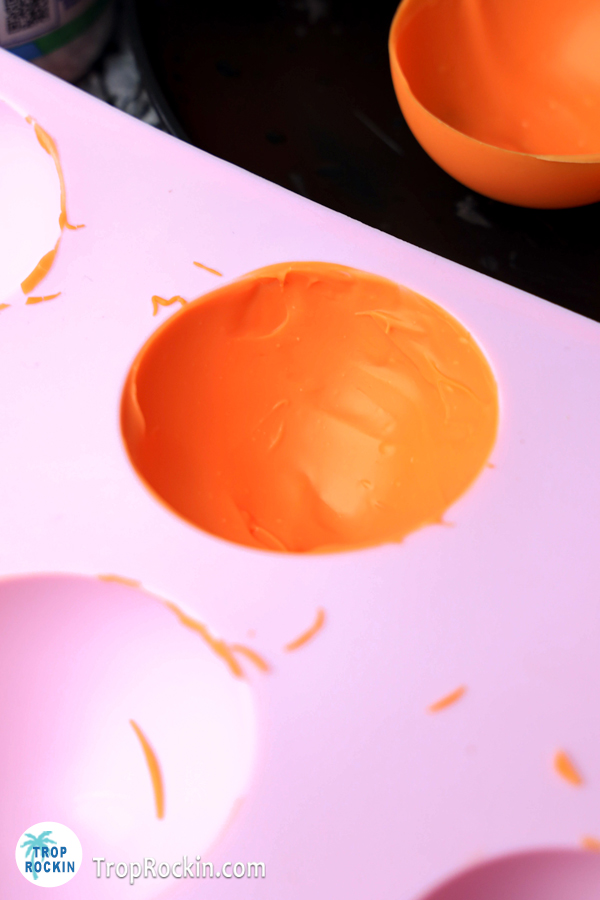 Silicone sphere coated with orange chocolate.