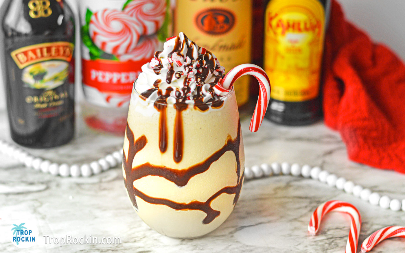 Peppermint Mudslide drink with liquor bottles in the background.