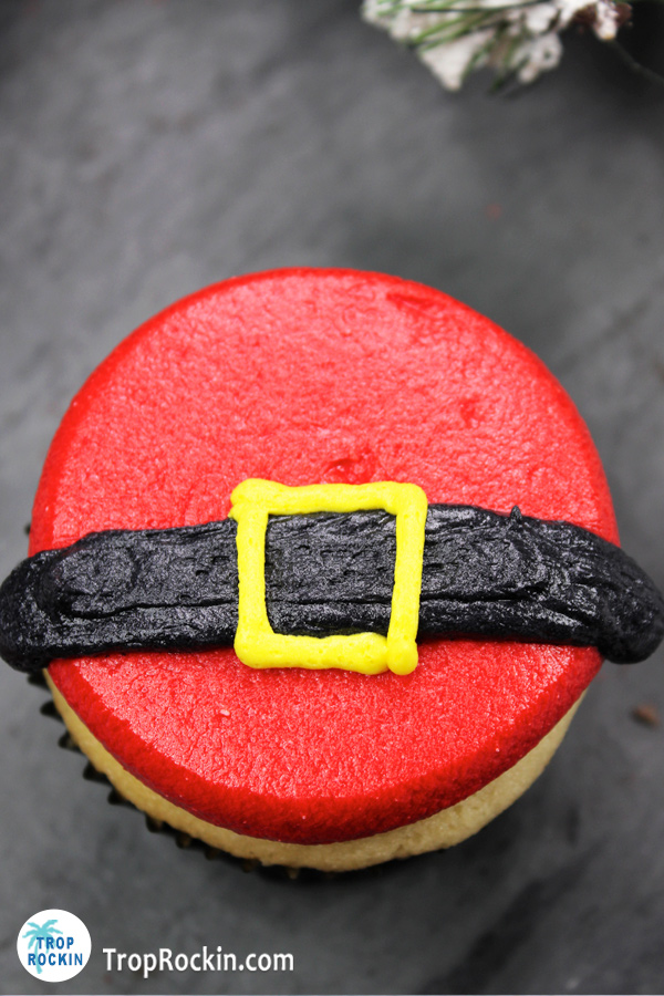 Santa cupcake with red frosting, black frosting belt and yellow frosting belt buckle.