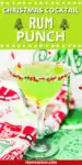 Green christmas rum cocktail with christmas sprinkles on the rim of a martini glass. Text overlay above that says " christmas cocktails. rum punch." for sharing to social media.