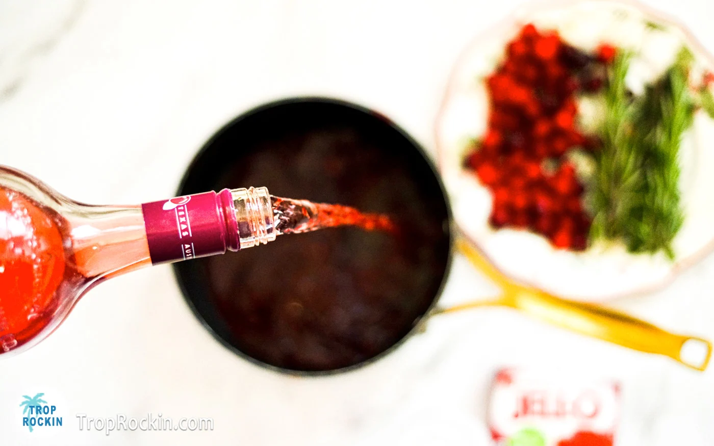 Pouring cranberry vodka into saucepan.
