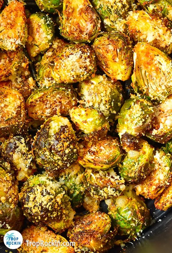 Up close of air fried brussels sprouts in the air fryer basket.