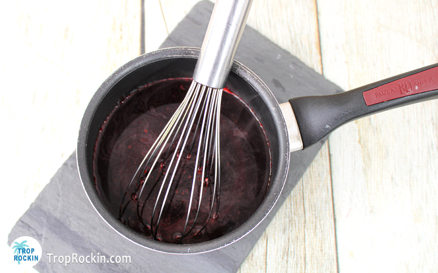 Jello mixture in a medium saucepan with a whisk.