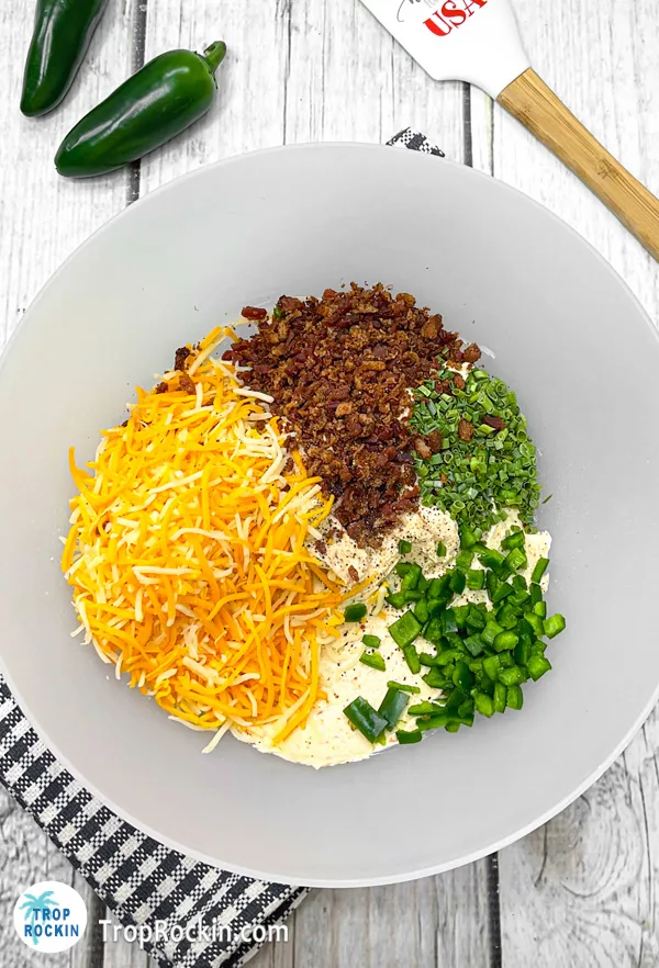 Mixing bowl with all cheese ball ingredients .