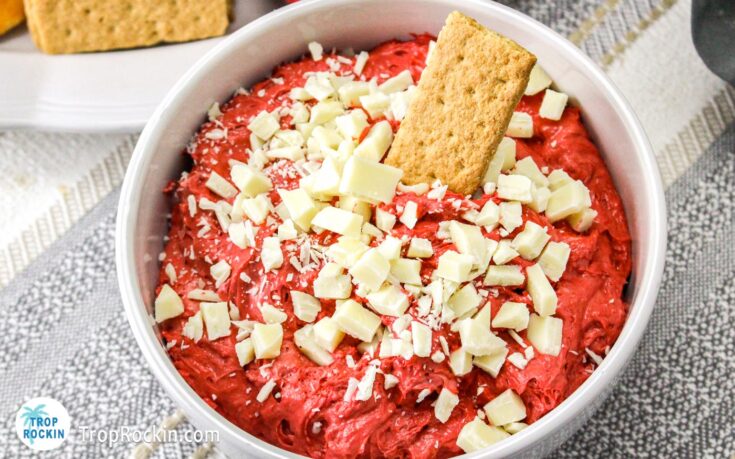 Bowl of Red Velvet Dip with white chocolate pieces on top and a graham cracker dipped in the dip.