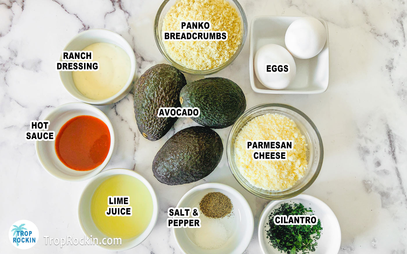Air fryer avocado fries ingredients and dipping sauce ingredients displayed on counter top in small bowls with 3 avocados in the center. Each ingredient is labeled with text overlay.