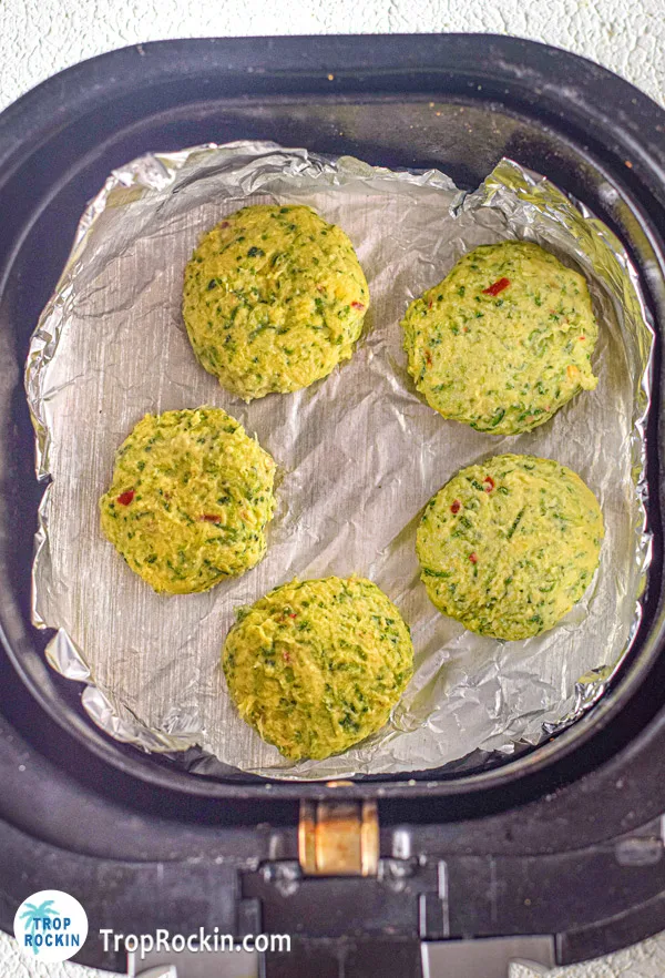 Zucchini fritters in air fryer basket.