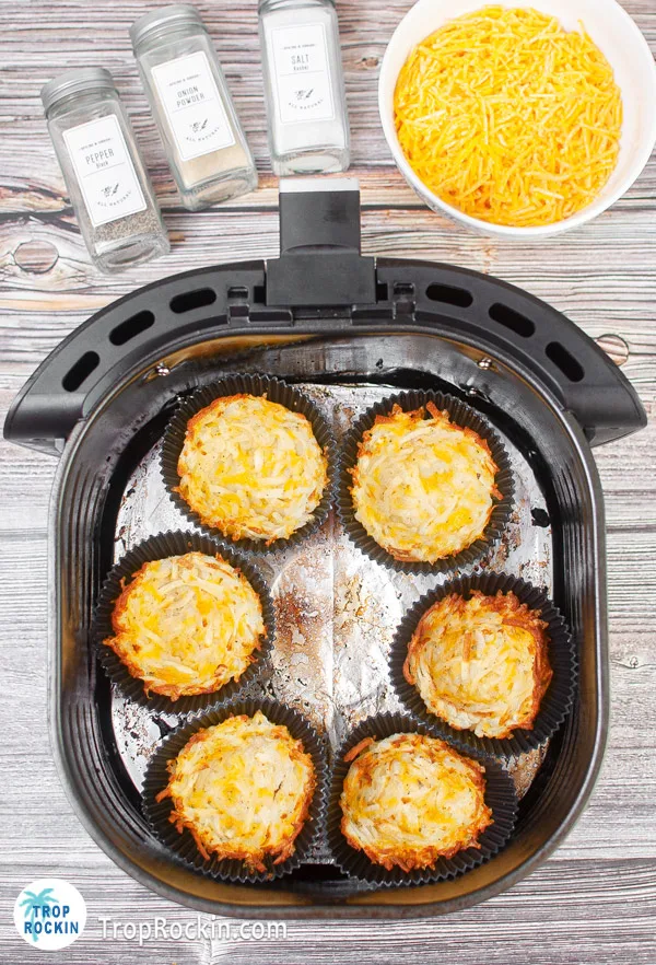 Cooked hash browns in silicone molds in the air fryer basket.