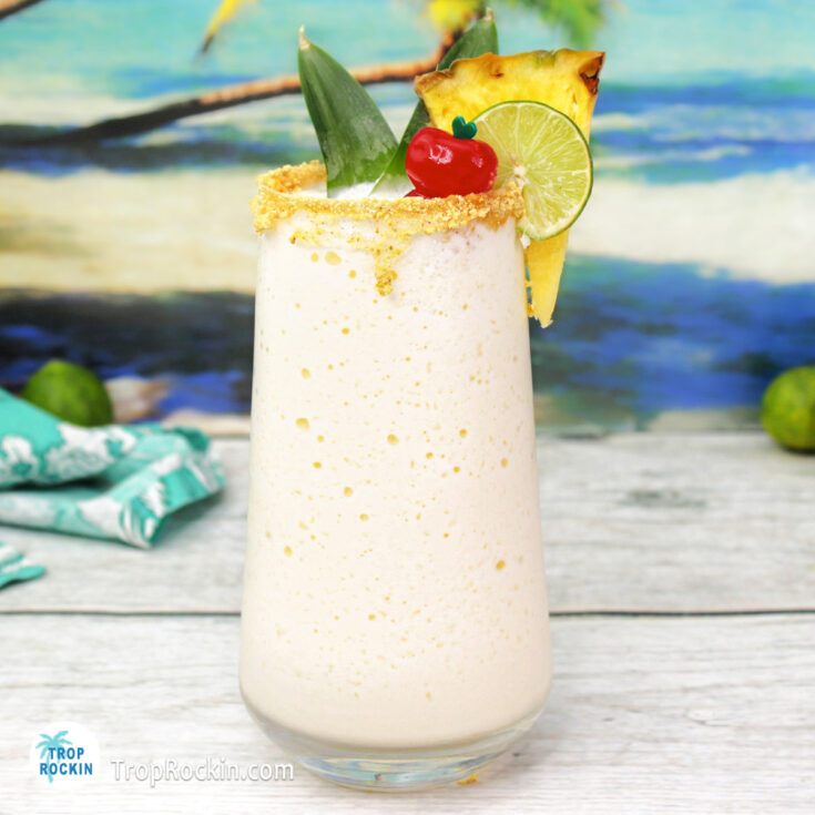 Key Lime Colada on wood counter top with a tropical beach background.