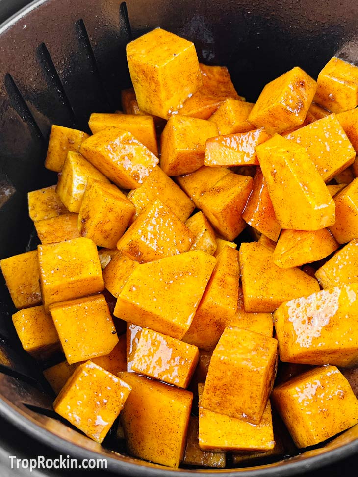 Cubed butternut squash in the air fryer basket.