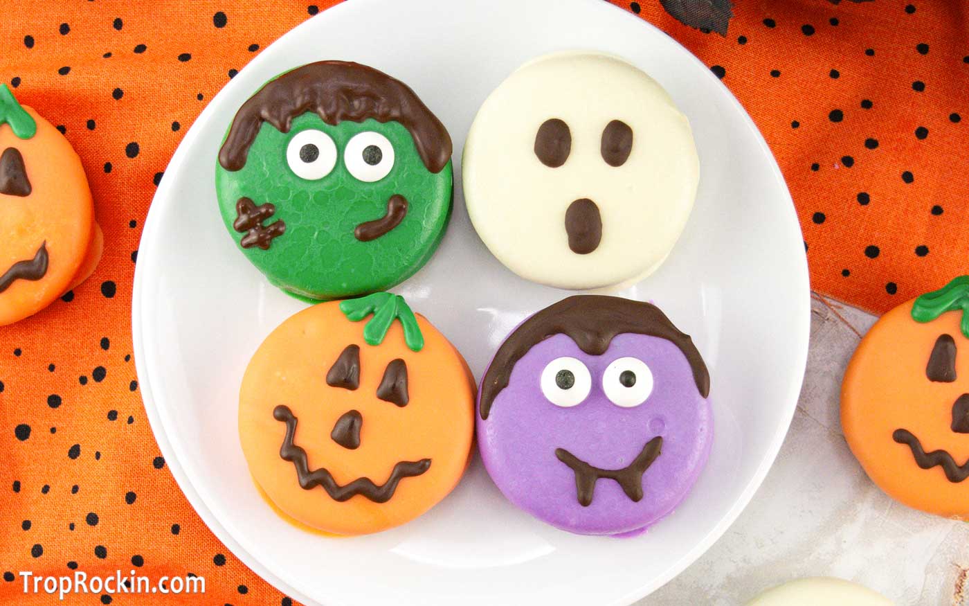 Halloween Chocolate Covered Oreos decorated in four ways: Green Frankenstein, Orange Jack-o-lantern,Purple Vampire and a white ghost.