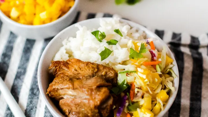 A bowl of rice with jerk chicken.