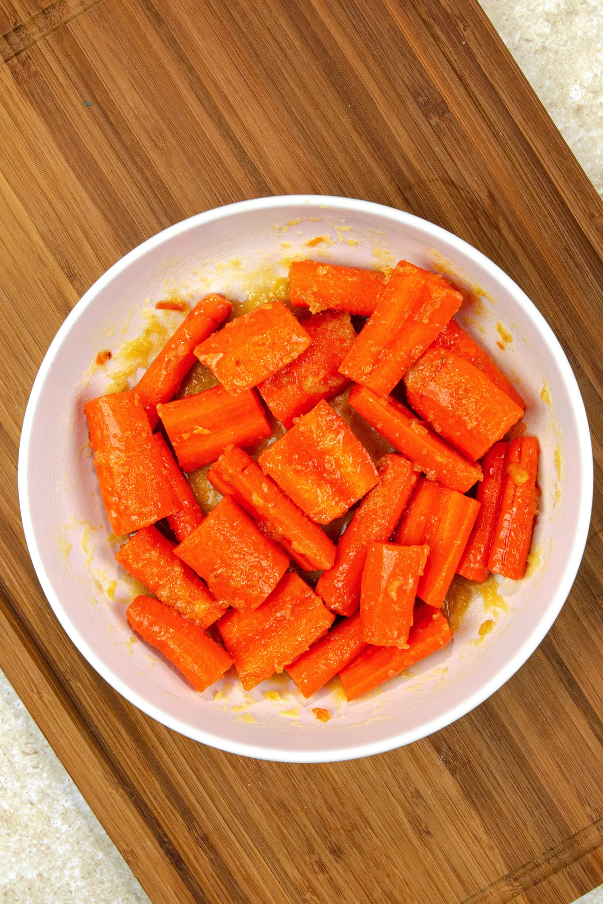 Bowl of sliced carrots with honey brown sugar glaze mixed in.