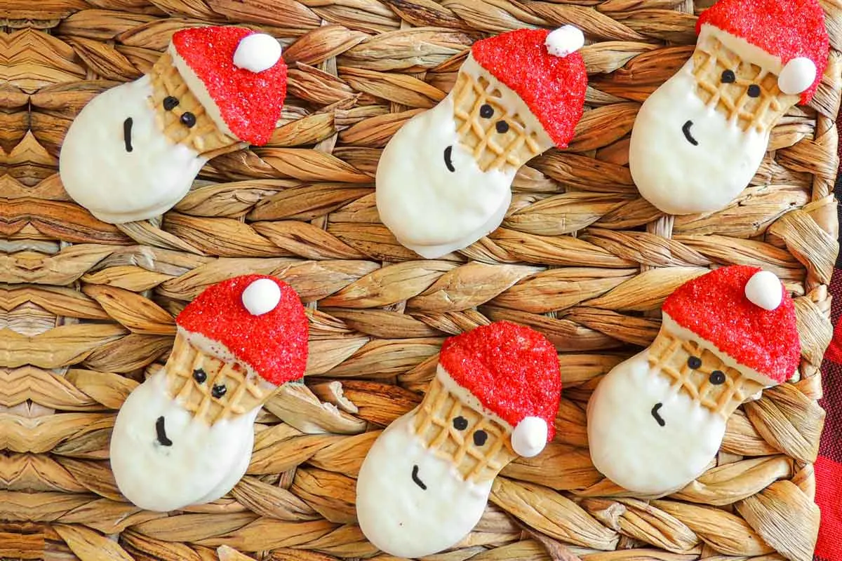 Nutter Butter Santa Cookies with red hats displayed on a place mat.