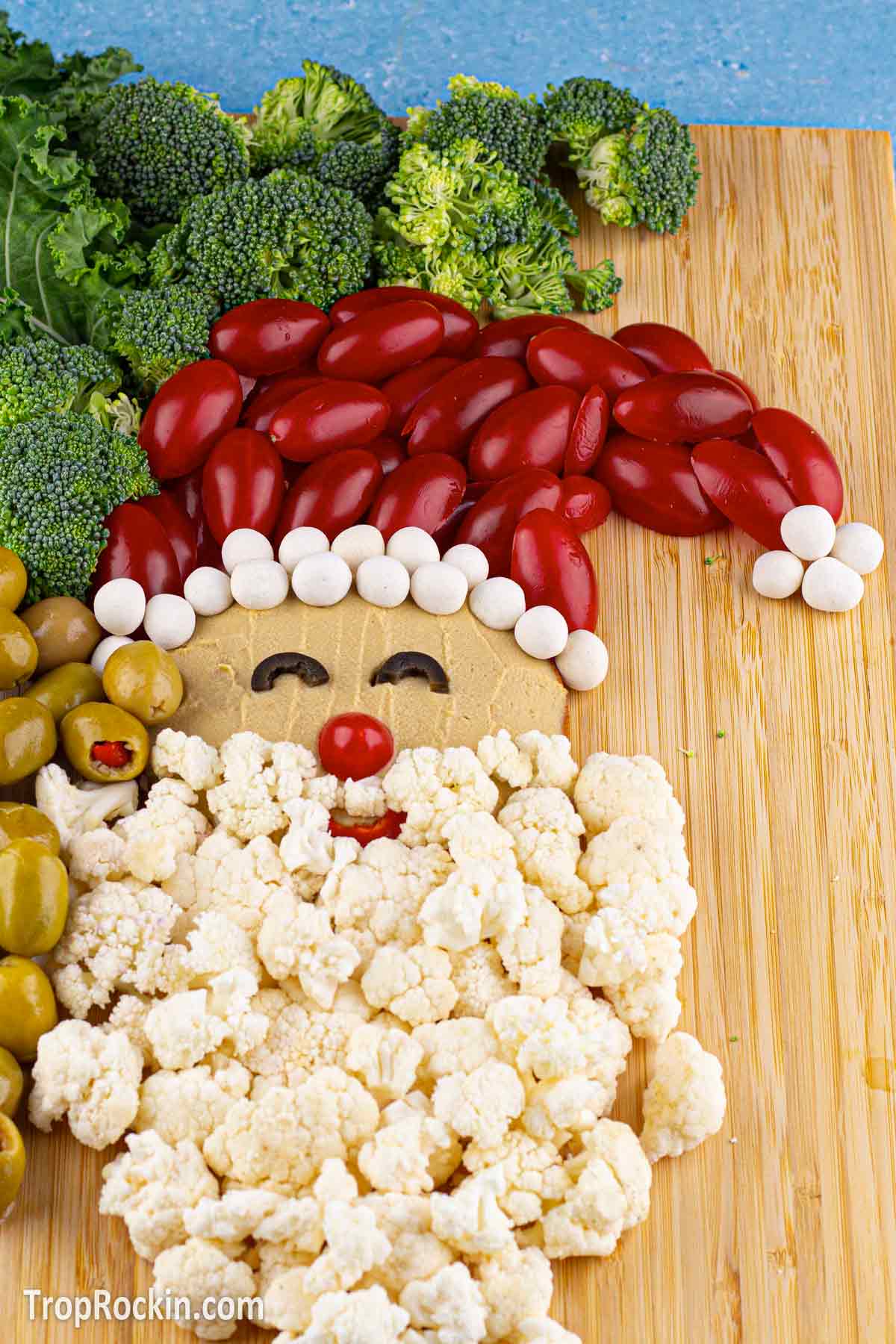 santa veggie tray with santa's hat made of cherry tomatoes.