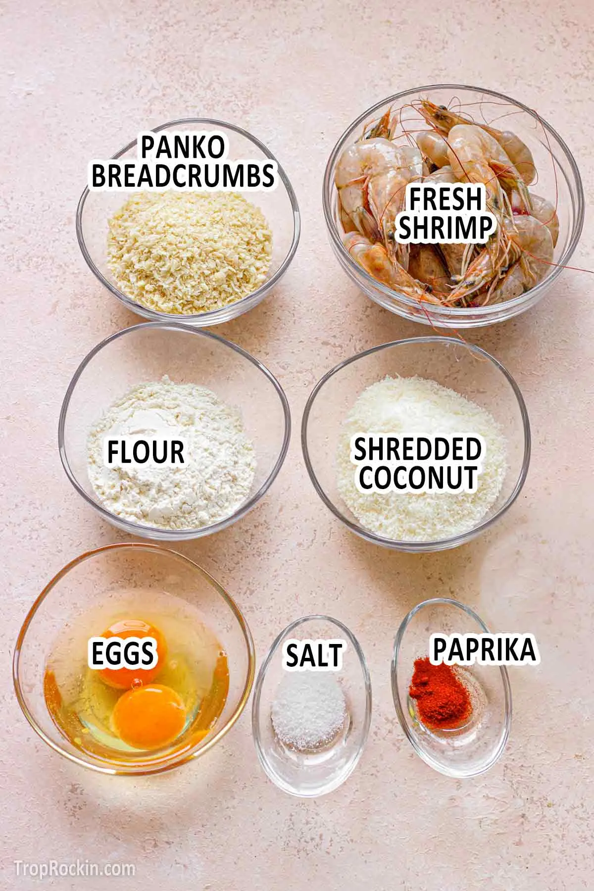 Air fryer coconut shrimp ingredients in small bowls displayed on counter top with text overlay labeling each ingredient.