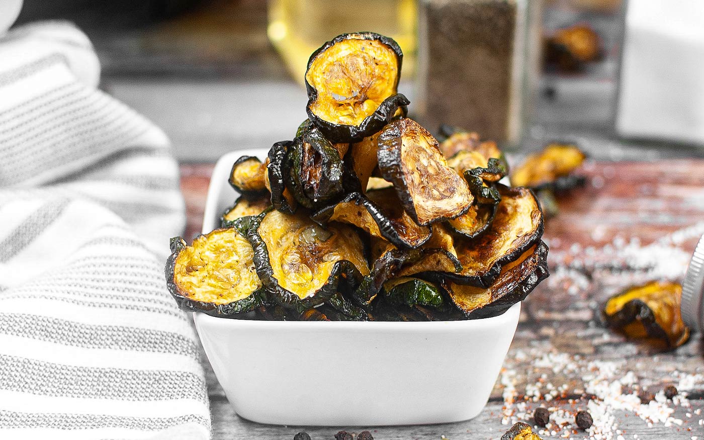 Air fryer zucchini chips stacked in a bowl.